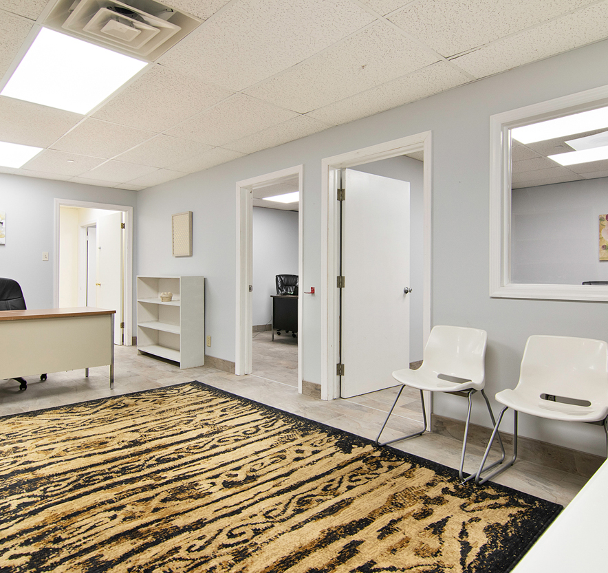 Office Setting Showcasing A Spacious Rug And White Chairs